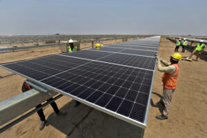 FILE PHOTO: Workers install solar panels at the Khavda Renewable Energy Park of Adani Green Energy Ltd (AGEL)  in Khavda, India, April 12, 2024.REUTERS/Amit Dave/File Photo