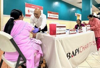 Dr. Vipul Patel (second from left) attending to a member and preparing her for the vaccination. PHOTO: Provided by Vipul Patel